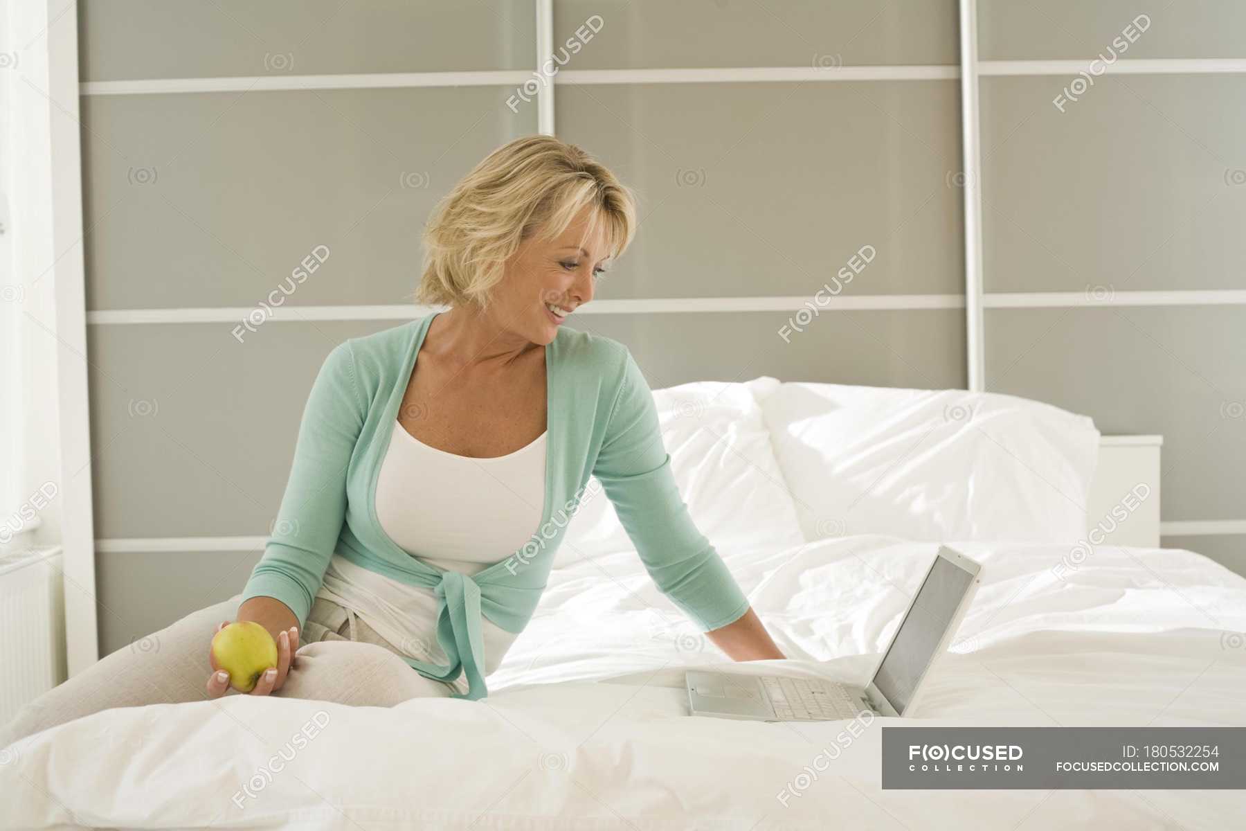 Mature women sitting on bed
