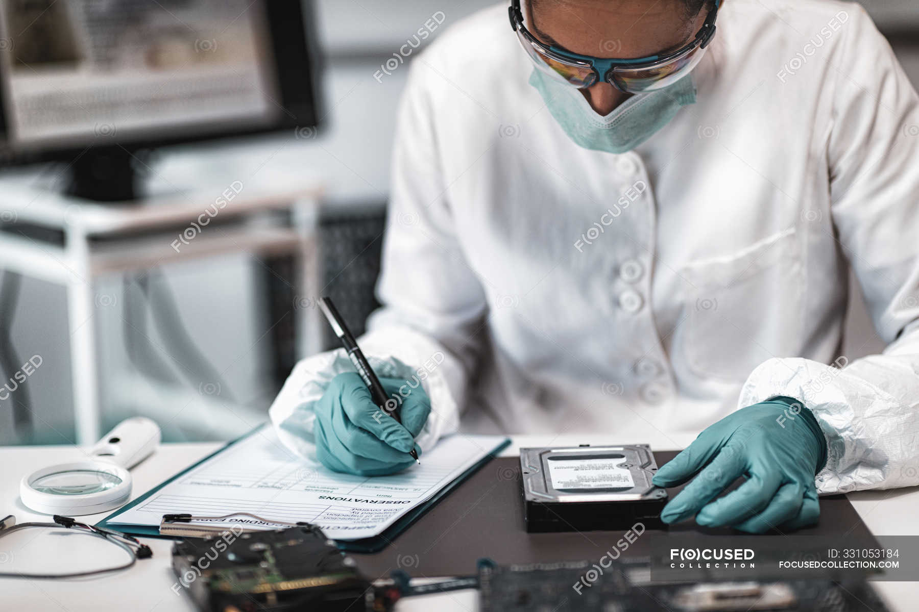 Female Digital Forensic Expert Examining Computer Hard Drive And Taking