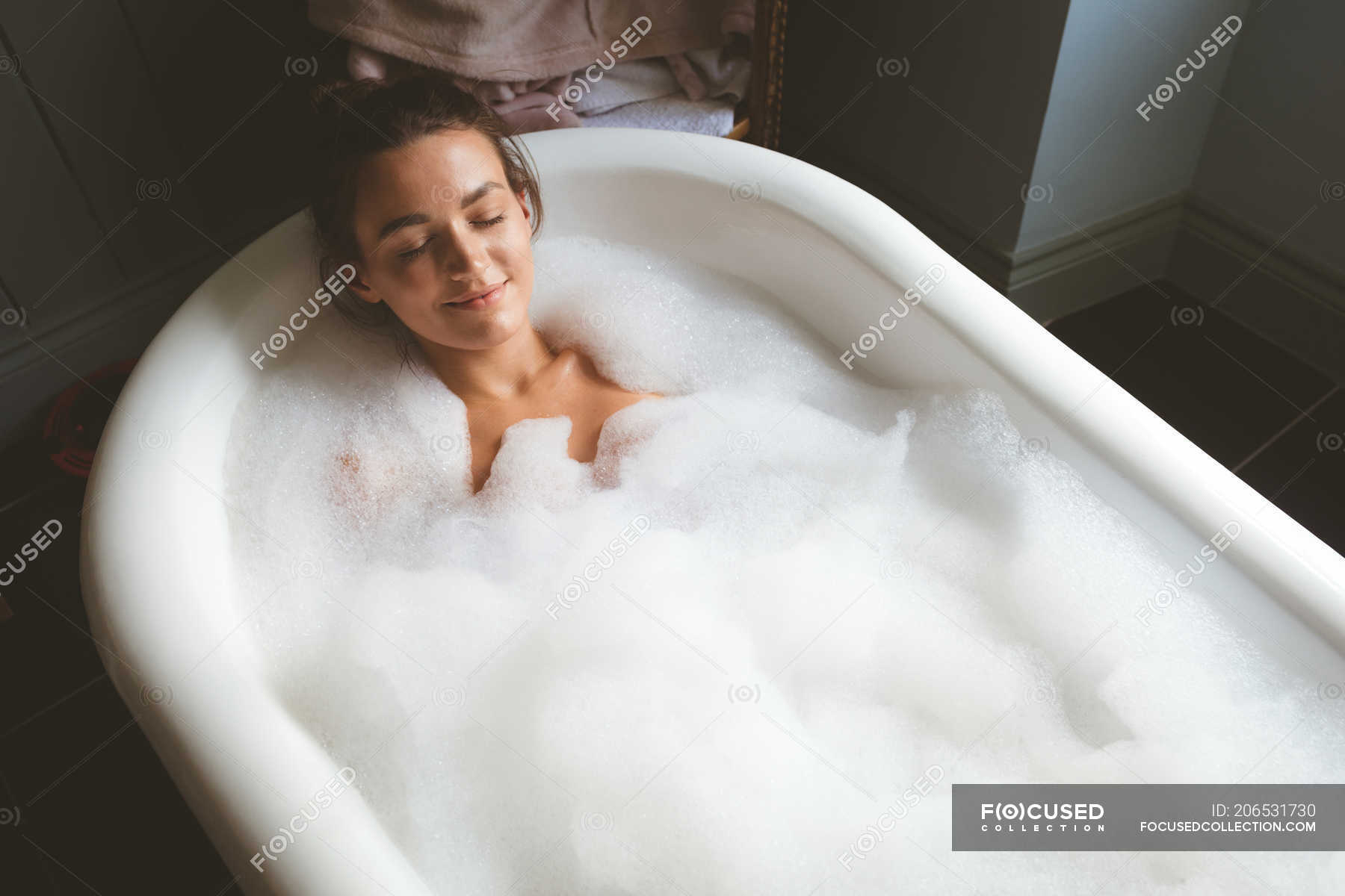 Грудастая темноволосая девушка принимает ванну