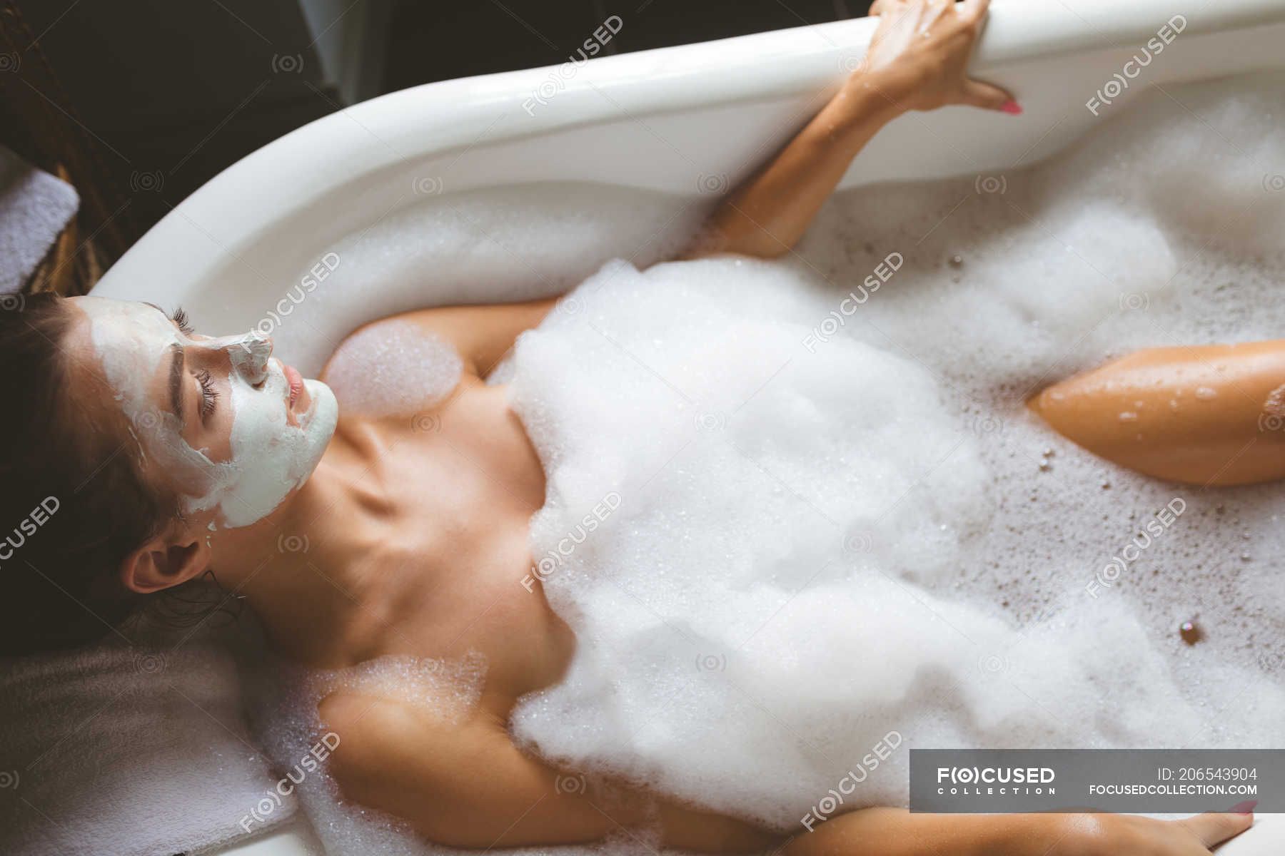 Прием расслабляющей ванны с пеной голой дамочки