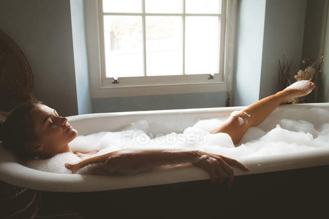 Скрытая камера над ванной засняла как одна девушка с волосатой пиздой лежит в ванной и читает