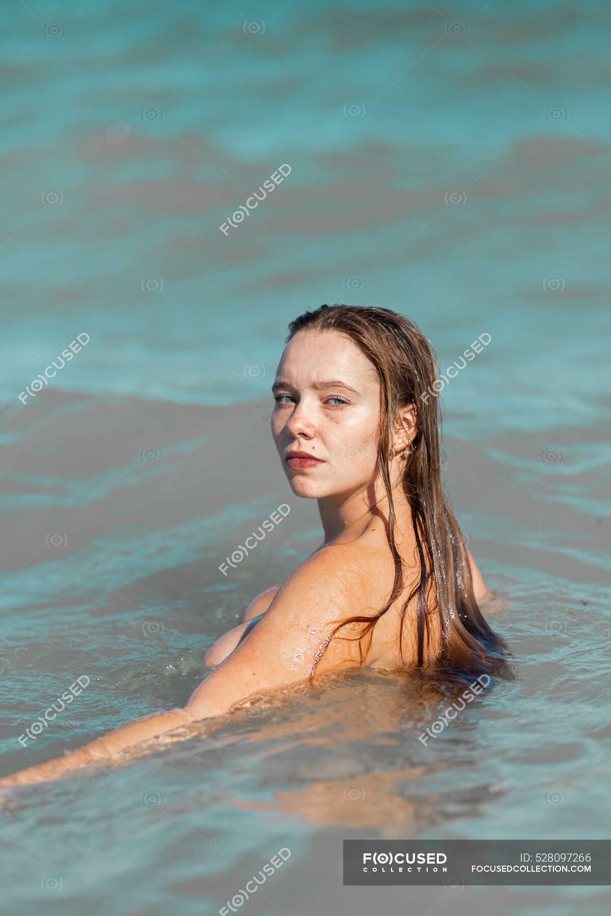 Mujer Desnuda Con El Pelo Mojado De Pie En Agua De Mar Mientras Mira A