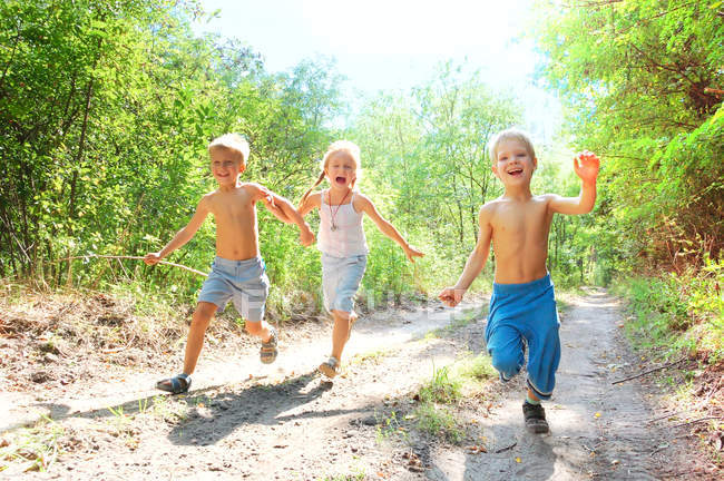 Two children running on a summer forest road. — Fotografia de Stock