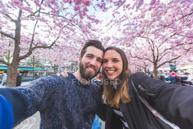 Coppia di hipster che si fa un selfie a Stoccolma con fiori di ciliegio — Foto stock