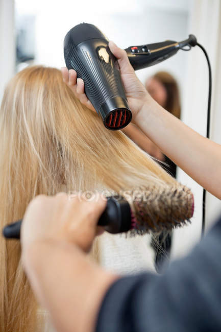 Stylist Asciugatura capelli donna nel salone parrucchiere — Foto stock