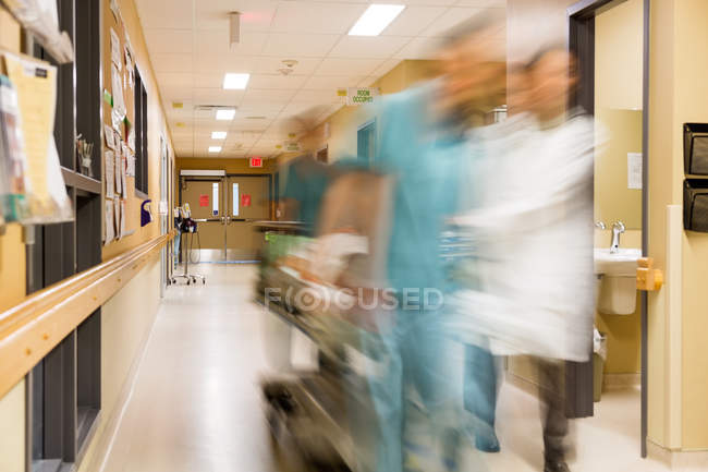 Médecin et infirmière tirant civière à l'hôpital — Photo de stock