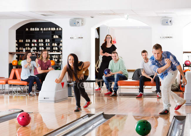 Jovens amigos jogando no bowling beco — Fotografia de Stock