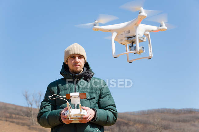 Mann steuert die fliegenden Drohnen — Stockfoto