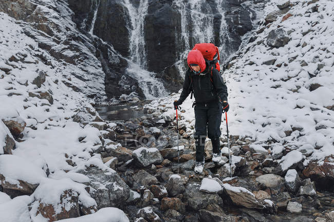 Hiker enjoy the leisure time at winter mountains. The trail passes near a large and beautiful waterfall — Stock Photo