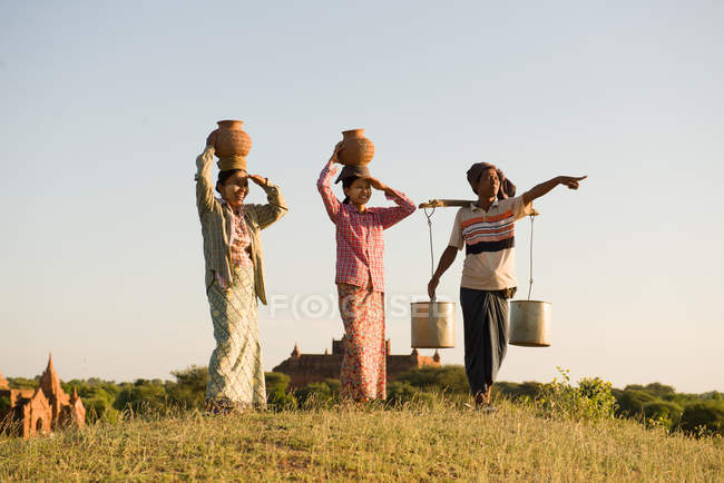 Contadino asiatico tradizionale che torna da un campo di grano raccolto — Foto stock