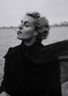 Femme fumant cigarette au bord de la mer — Photo de stock