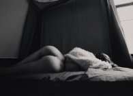Femme avec la culasse sexuelle posée sur le lit — Photo de stock