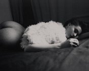Femme avec la culasse sexuelle posée sur le lit — Photo de stock