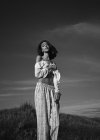 Mujer posando en pradera con paisaje rural - foto de stock