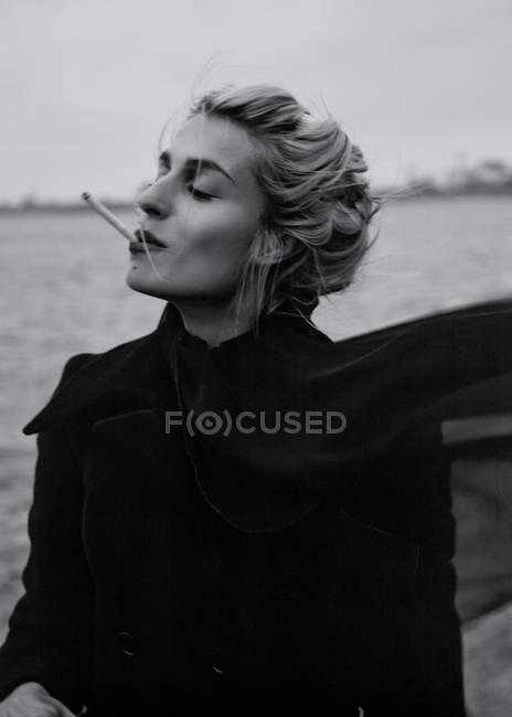 Mulher fumar cigarro à beira-mar — Fotografia de Stock