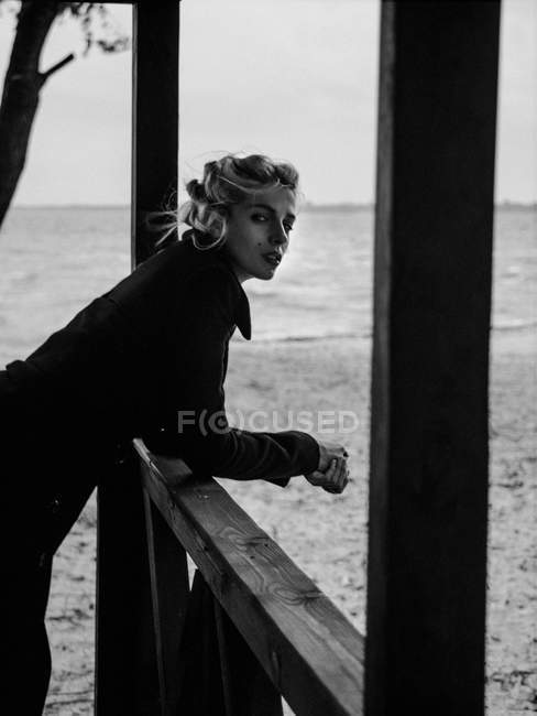 Femme penché sur la rampe et regardant la caméra — Photo de stock