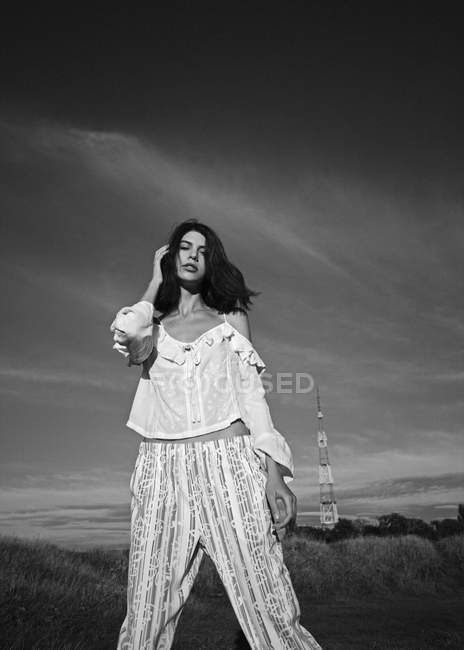 Femme posant dans la prairie avec paysage rural — Photo de stock