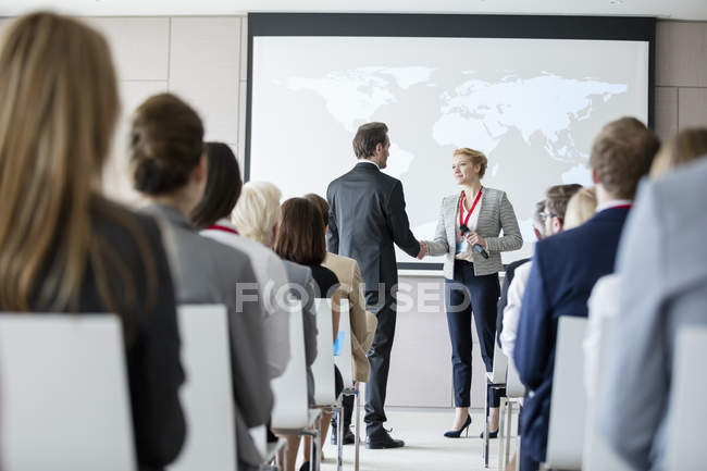 Business people shaking hands during seminar — Stock Photo