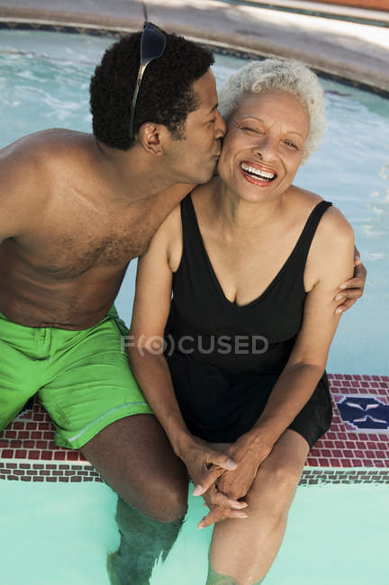 Чоловік цілує матір у басейні — стокове фото