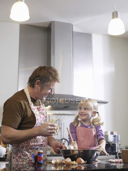 Niña y padre horneando - foto de stock