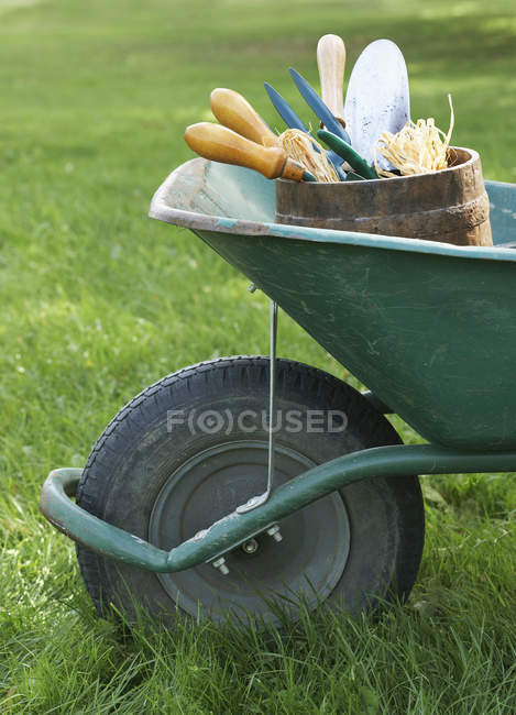 Carretilla con herramientas de jardinería - foto de stock