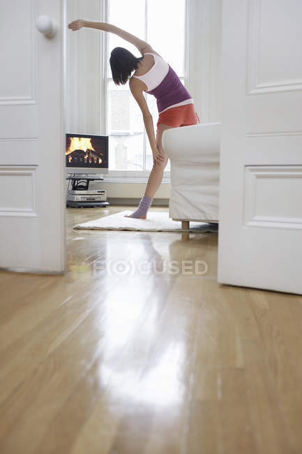 Woman exercising and watching television — Stock Photo