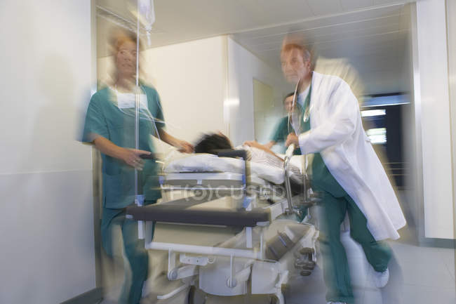 Médecins en marche Patient sur brancard — Photo de stock