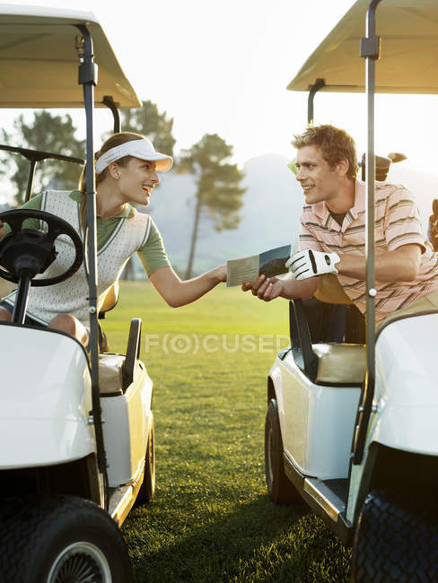 Golfers sitting in golf carts — Stock Photo