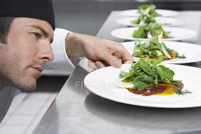 Chef maschile preparare insalata — Foto stock