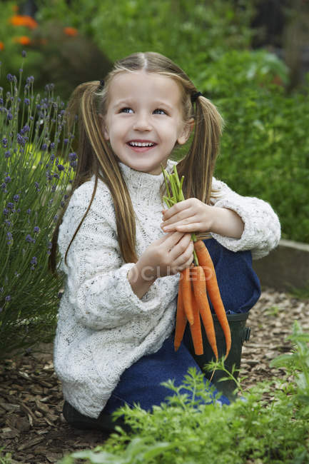 Fille avec des carottes fraîches cueillies — Photo de stock