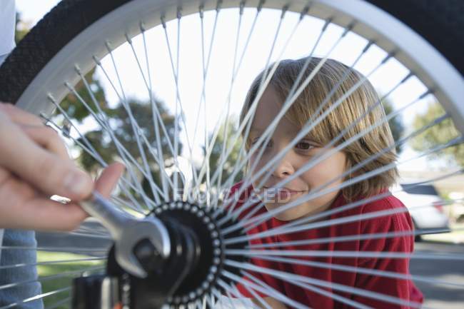 Garçon regarder au pneu de vélo — Photo de stock