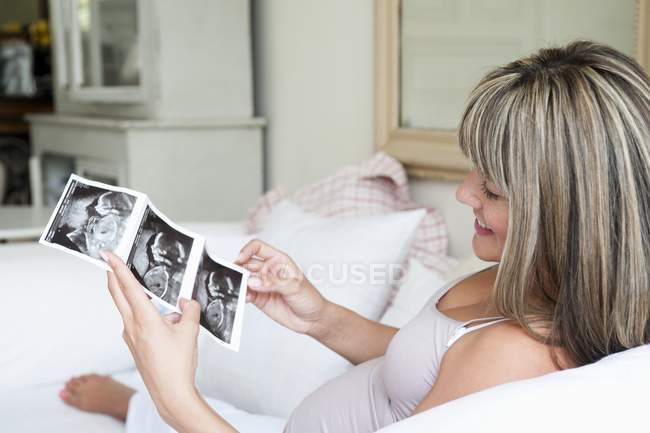 Femme enceinte sur le canapé — Photo de stock