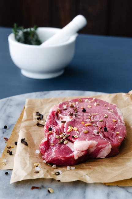 Première coupe de boeuf cru sur papier de boucherie — Photo de stock