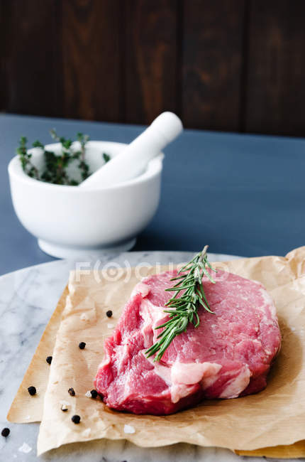 Première coupe de boeuf cru sur papier de boucherie — Photo de stock