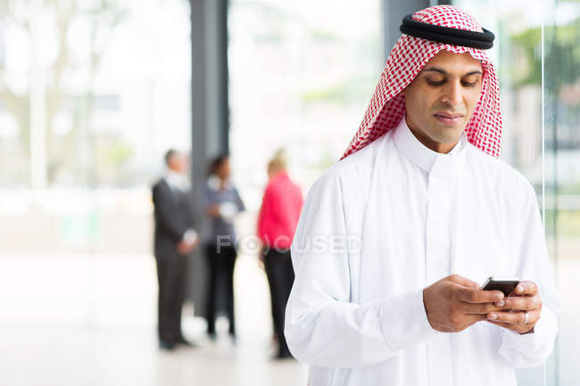 Islamic businessman using smartphone — Stock Photo