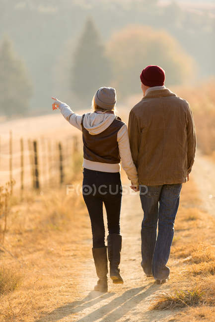 Pareja caminando en camino de campo - foto de stock