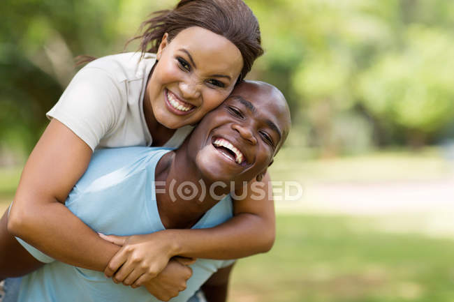 Couple piggybacking outdoors — Stock Photo