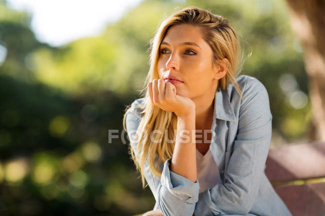 Woman sitting alone outdoors — Stock Photo