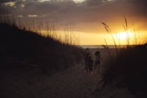 Niños corriendo en la playa de arena - foto de stock