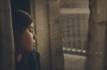 Продумана дівчина дивиться на вікно — стокове фото