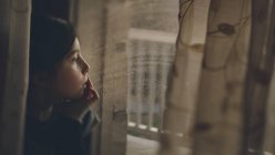 Задумчивая девушка смотрит в окно — стоковое фото