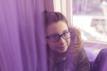 Дівчина в окулярах сидить на підвіконні — стокове фото