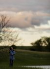 Girl looking at cloudy sunset sky — Stock Photo