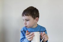 Мальчик пьет из чашки — стоковое фото