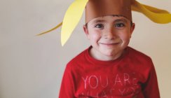 Junge mit lustigem Papierhut — Stockfoto