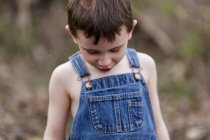 Симпатичный мальчик в джинсовом комбинезоне — стоковое фото