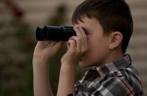 Rapaz bonito olhando em binóculos — Fotografia de Stock