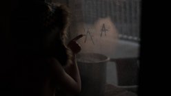 Мальчик рисует через туманное окно — стоковое фото