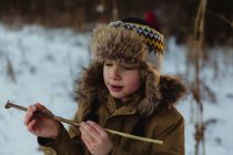 Мальчик держит деревянную палку — стоковое фото