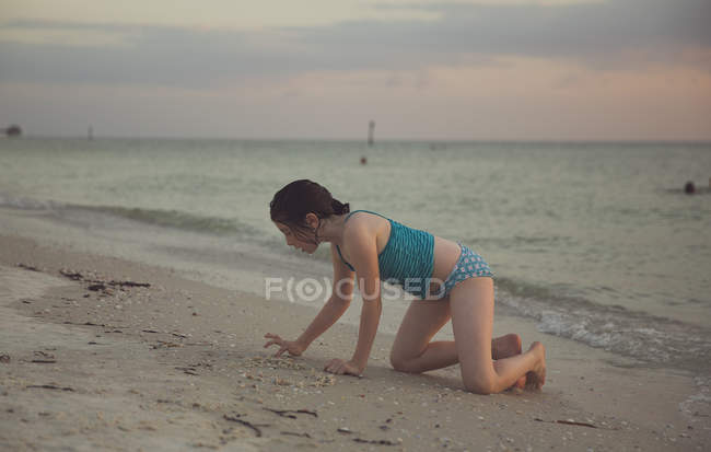 Menina brincando na areia na praia — Fotografia de Stock
